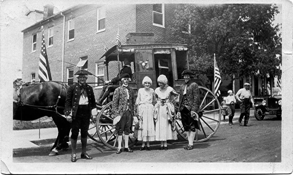 old photo of colonial people next to carriage