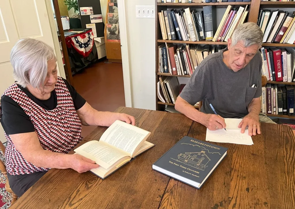 two people researching at a table
