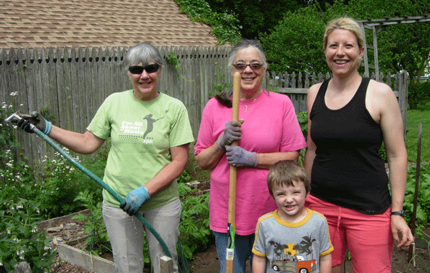 family gathered in garden doing gardening work